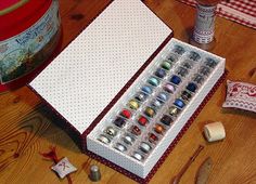 an open box filled with lots of crafting supplies on top of a wooden table