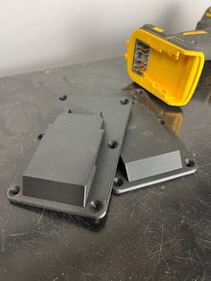 two yellow and gray boxes sitting on top of a metal table