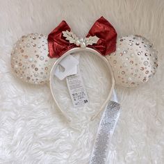 a minnie mouse ears headband with red and white sequins on it, next to a price tag