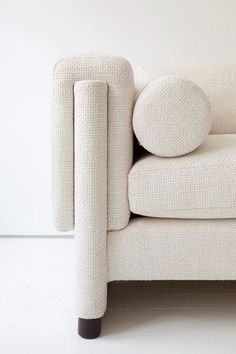 a white couch sitting on top of a hard wood floor