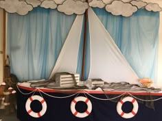 a boat made out of paper with clouds on the top and a life preserver at the bottom