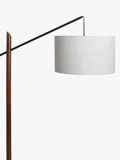 a floor lamp with a white fabric shade on the top and a wooden pole underneath it