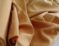 a roll of tan colored fabric sitting on top of a bed