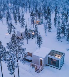 small cabins in the snow surrounded by trees and lights at night, as seen from above