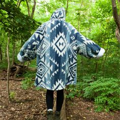 a person wearing a blue and white coat in the woods