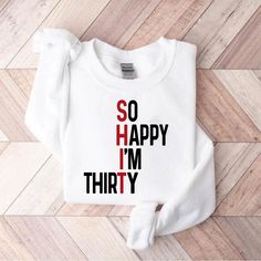 a white sweater with the words so happy i'm thirty printed on it