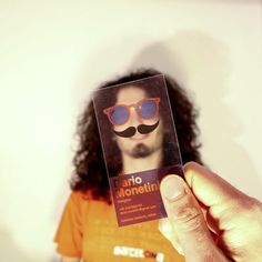 a person holding up a card with a mustache and sunglasses on it's face