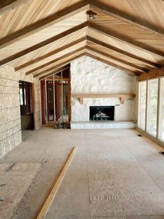 an empty living room with wood beams on the ceiling and fireplace in the center area