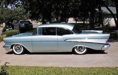 an old car is parked in the driveway