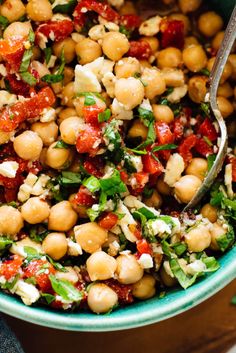 a bowl filled with chickpeas, tomatoes and feta cheese