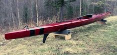 a red canoe sitting on top of a wooden bench