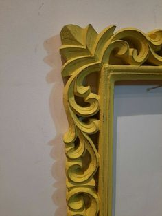 an ornate yellow frame hanging on the wall