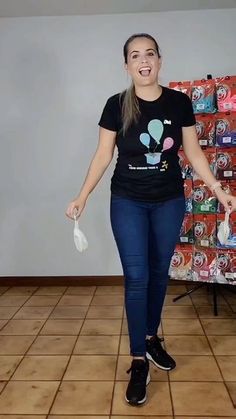 a woman standing in front of a pile of soda cans