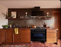 a stove top oven sitting inside of a kitchen next to wooden cabinets and counter tops