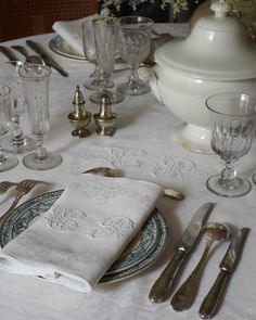 the table is set with silverware and white linens, including an empty napkin