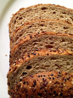 slices of bread on a white plate with black seeds and sesame seed sprinkles