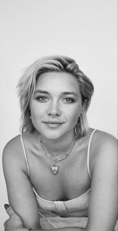 a black and white photo of a woman with her arms crossed looking at the camera