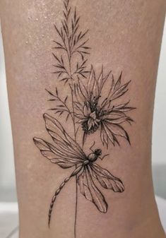 a black and white flower tattoo on the ankle