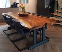 a wooden table sitting in the middle of a living room next to a stair case