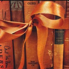 an orange ribbon tied on top of old books