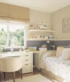 a bed room with a neatly made bed and a desk in front of a window