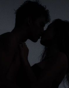 a man and woman kissing in the dark