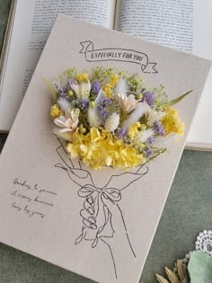 a bouquet of flowers sitting on top of an open book