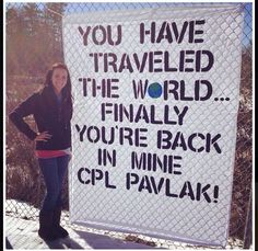 a woman standing in front of a sign that says you have traveled the world finally you're back in mine cpu pavlakk