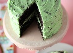 a cake with green frosting and chocolate sprinkles is cut in half