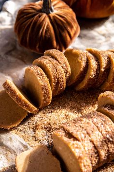 pumpkins and cinnamon sugar are on the table next to some cut - up cookies