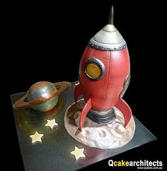 a red toy rocket ship sitting on top of a table next to a small planet