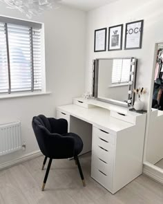 a white desk with a chair and mirror in front of it, next to a window