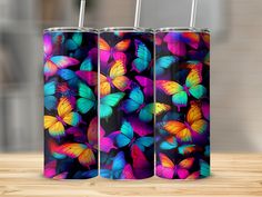 three colorful butterflies are on the same color as they appear in this tumbler cup