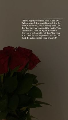 a vase filled with red roses sitting on top of a table next to a wall