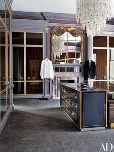 an elegant bedroom with mirrored closets and chandelier hanging from the ceiling above