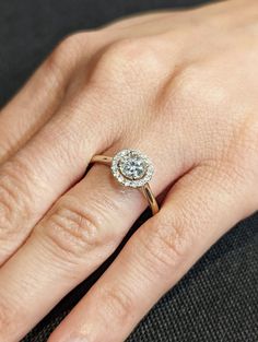 a woman's hand with a diamond ring on top of her finger and an engagement band