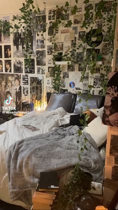 an unmade bed sitting in a bedroom next to a wall with pictures on it