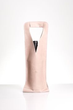 a wine bottle in a bag on a white surface with a black object sticking out of it