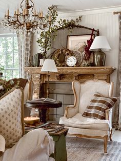 a living room filled with furniture and a fire place under a chandelier next to a window