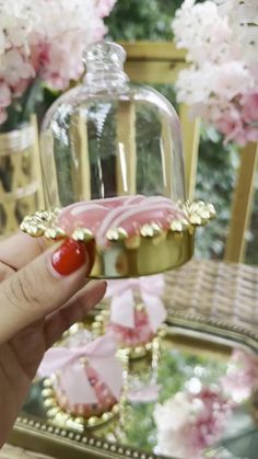 a hand holding a piece of cake in front of a clochet with pink flowers