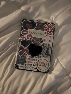 a cell phone with stickers on it laying on a bed