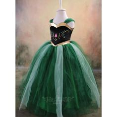 a green tulle skirt with black and white cat ears on the top, sitting in front of a painting