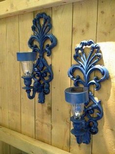 two blue wall sconces mounted to the side of a wooden wall