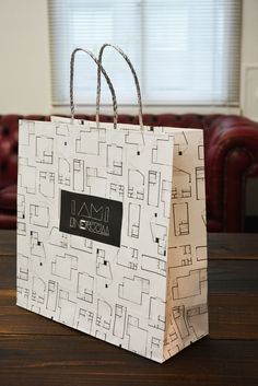 a white shopping bag sitting on top of a wooden table