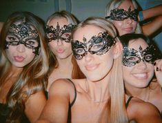 a group of young women wearing masquerades posing for a photo in front of the camera