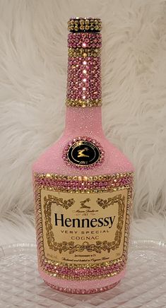 a bottle of hennesy pink and gold liquid on a white furnishing