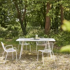 an outdoor table and chairs in the woods