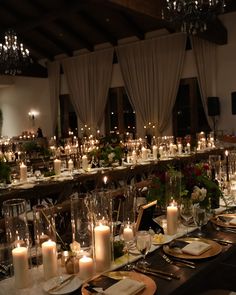 a long table is set with candles and place settings for dinner guests to eat at