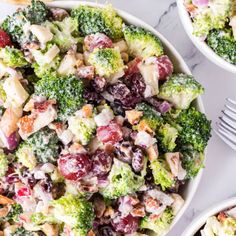 broccoli salad with cranberries, grapes and chicken in two white bowls