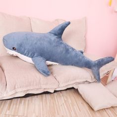 a stuffed shark laying on top of a couch